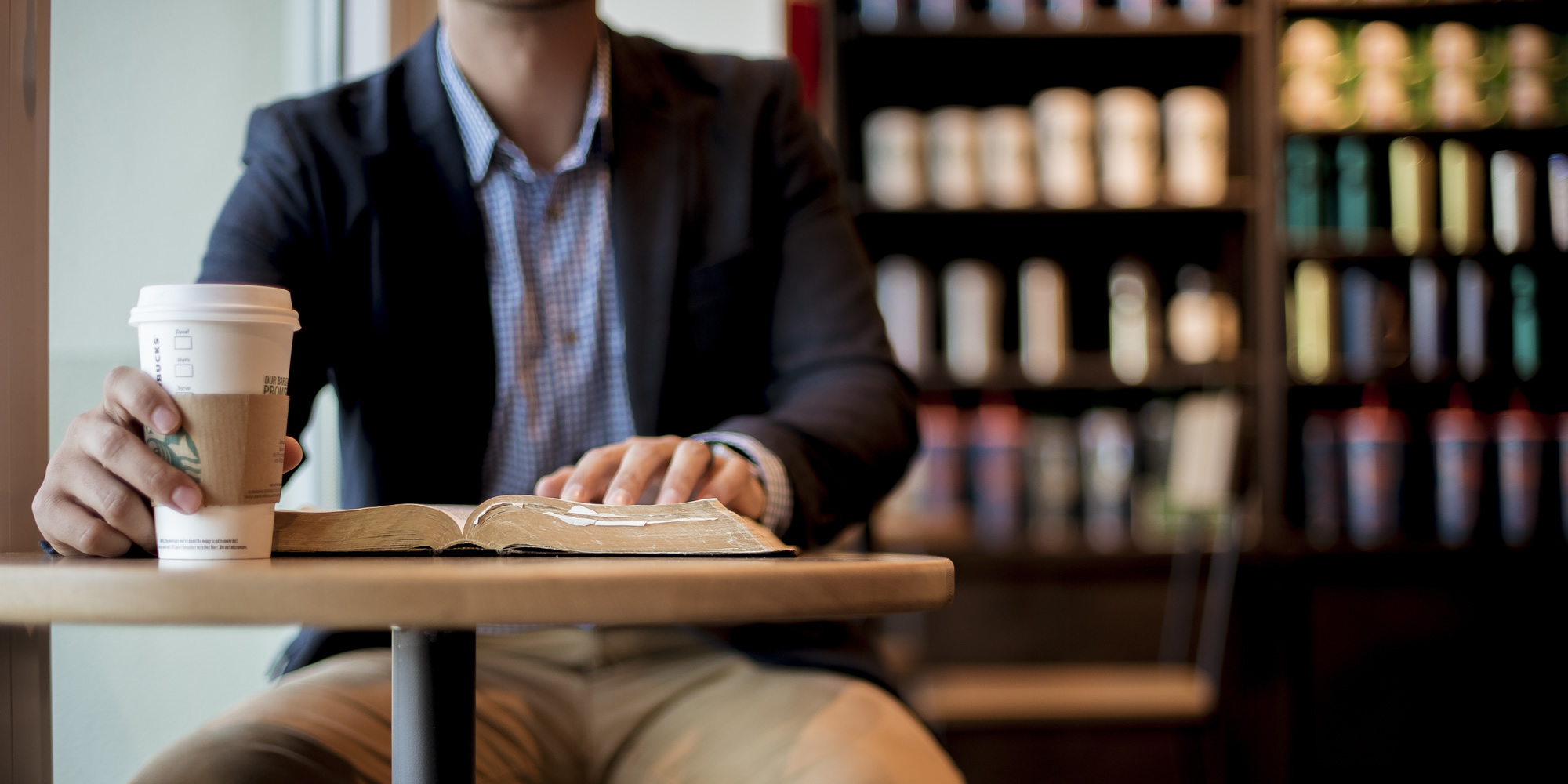 Individual Learning Hero Image (man at table with book and coffee)
